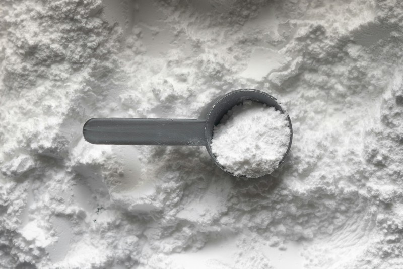 Creatine in a spoon on top of spilled creatine