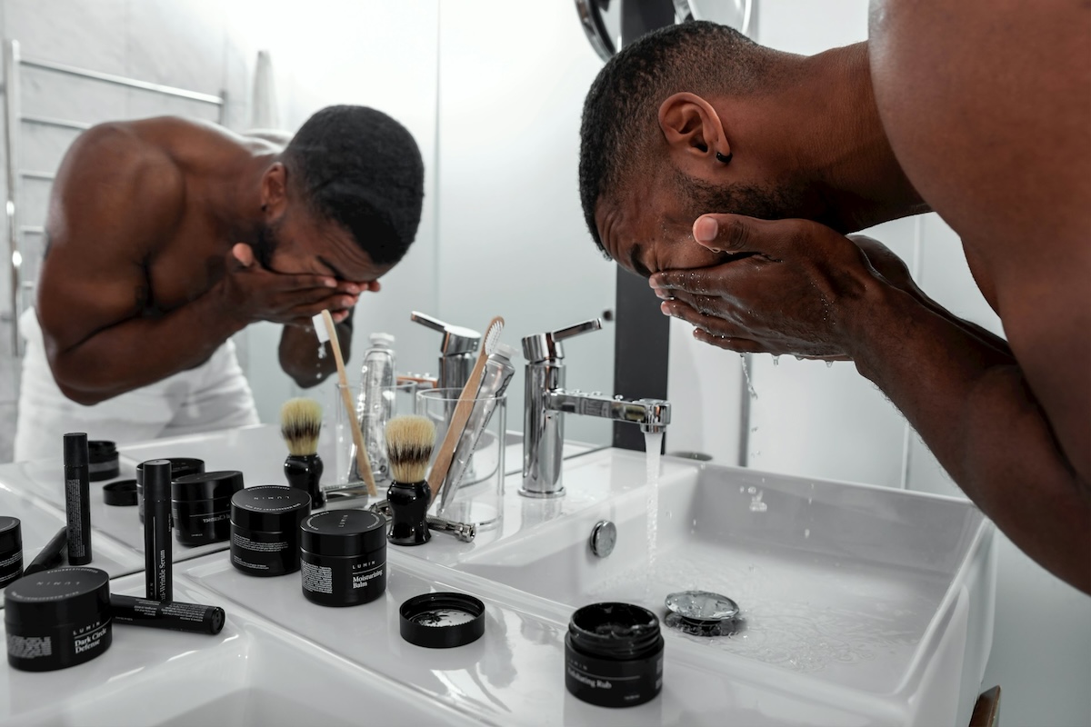 a man washing his face by skincare products